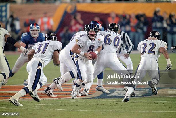 Trent Dilfer of the Baltimore Ravens turns to hand the ball off to running back Jamal Lewis against the New York Giants during Super Bowl XXXV at...