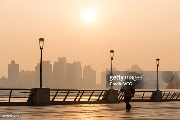 Man walks at The Bund as heavy smog engulfs the city on December 25, 2013 in Shanghai, China. Heavy smog covered many parts of China on Christmas...