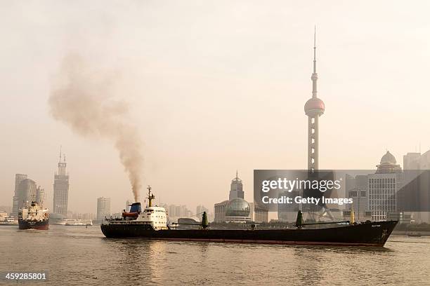 Ships sail up the Huangpu River as heavy smog engulfs the city on December 25, 2013 in Shanghai, China. Heavy smog covered many parts of China on...
