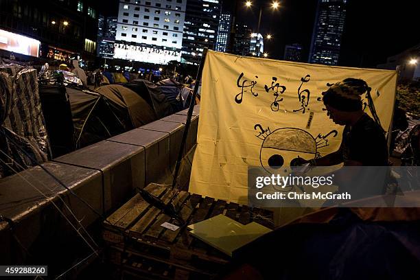 Pro-democracy activist works on putting up a banner at his tent on the road outside Hong Kong's Government complex on November 20, 2014 in Hong Kong....