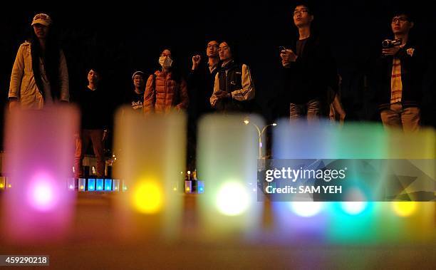 Supporters of the transgender community stand behind candle during a demonstration at Taipei freedom square on November 20, 2014. Dozens gathered...