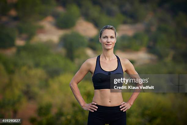 fit yoga teacher standing & smiling confident - bra top stock pictures, royalty-free photos & images