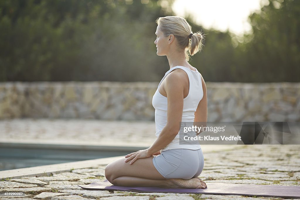 Fit yoga teacher making Virasana (Hero Pose)