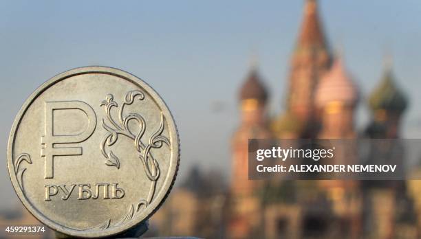 Russian ruble coin is pictured in front of St. Basil cathedral in central Moscow, on November 20, 2014. After having recently spent billions of...