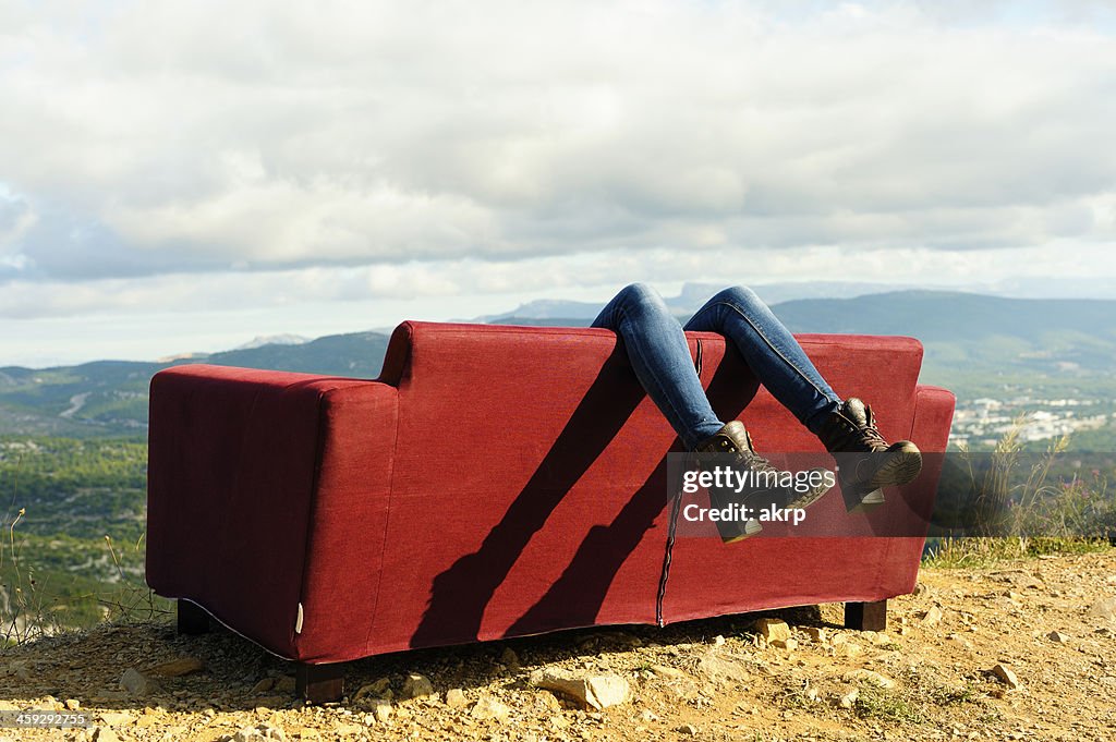 Young woman lying on a couch outdoors