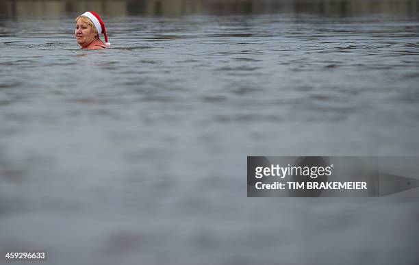 Member of the "Berlin Seals" swim association takes a bath in the Orankesee lake in Berlin during their tradtional Christmas Swimming on December 25,...