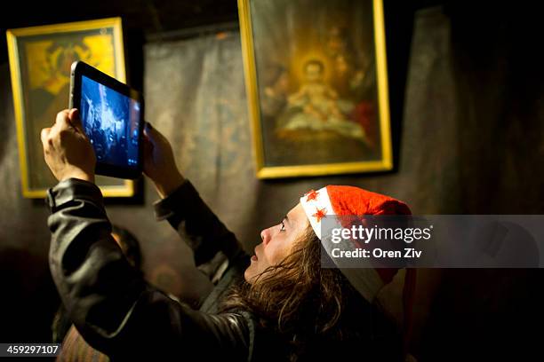 Christian worshipper uses her ipad to take photos at the Grotto at the Church of the Nativity on December 25, 2013 in Bethlehem, West Bank. Every...