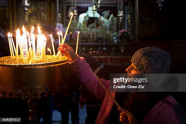 Christian worshipper lights candles at the Church of the Nativity on December 25, 2013 in Bethlehem, West Bank. Every Christmas pilgrims travel to...