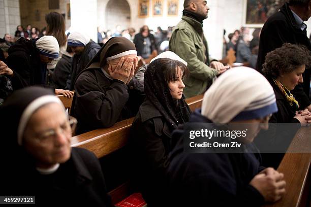 Christian nuns pray during the Christmas mass at the Church of the Nativity on December 25, 2013 in Bethlehem, West Bank. Every Christmas pilgrims...