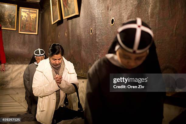 Christian nuns and worshippers pray at the Grotto at the Church of the Nativity on December 25, 2013 in Bethlehem, West Bank. Every Christmas...