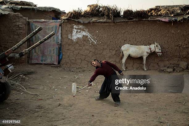 An Afghan refugee boy plays with a plastic bottle in Islamabad, Pakistan, on Universal Children's Day signed in 1989 by the United Nations and other...