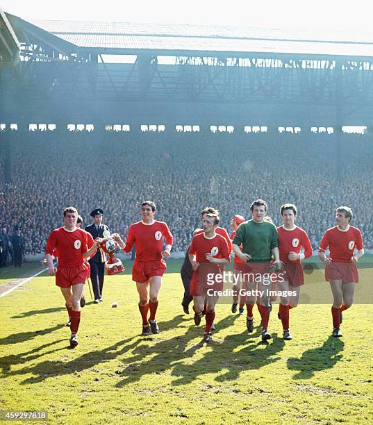Liverpool captain Ron Yeats carrying a paper-mache model of the Championship trophy with his team mates after Liverpool seal the 1963/64 League...