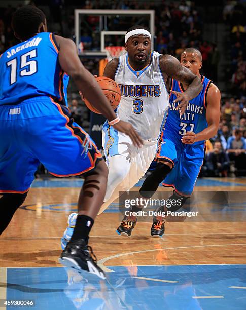 Ty Lawson of the Denver Nuggets controls the ball against the defense of Reggie Jackson and Sebastian Telfair of the Oklahoma City Thunder at Pepsi...