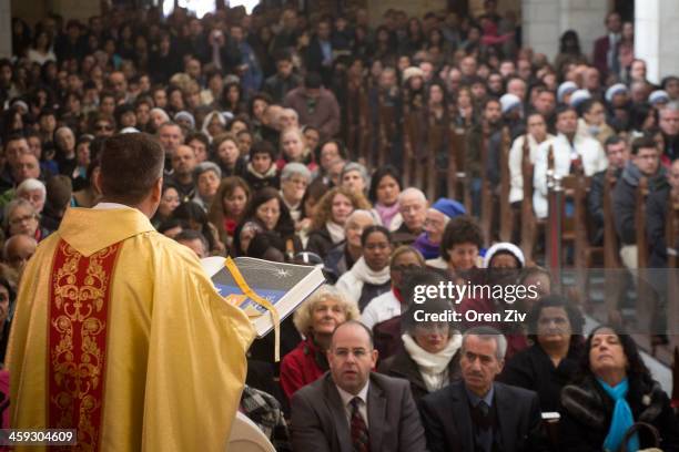 Christian worshippers attend a Christmas mass at the Church of the Nativity on December 25, 2013 in Bethlehem, West Bank. Every Christmas pilgrims...