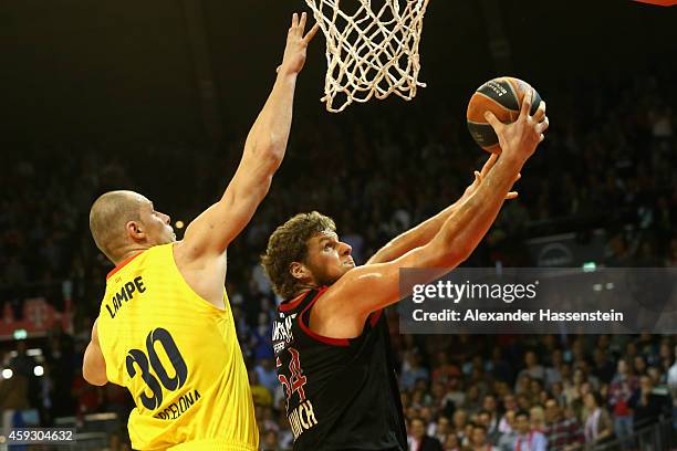 John Bryant of Bayern Muenchen iscores a point against Maciej Lampe of Barcelona during the Euroleague Basketball match between FC Bayern Munich and...