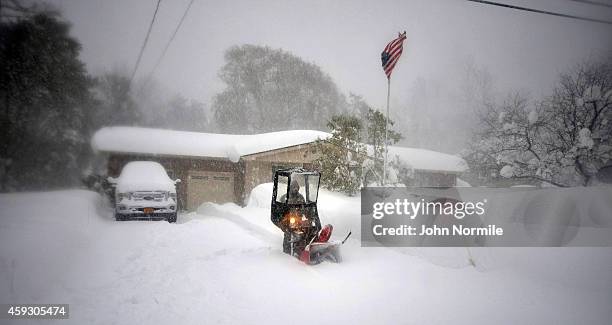 Norbert Schnorr attempts to remove some of the five feet of snow from a driveway on November 20, 2014 in the suburb of Lakeview, Buffalo, New York....