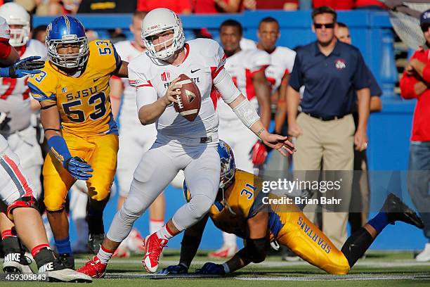 Quarterback Derek Carr of the Fresno State Bulldogs eludes a tackle by linebacker Keith Smith of the San Jose State Spartans as he scrambles for six...