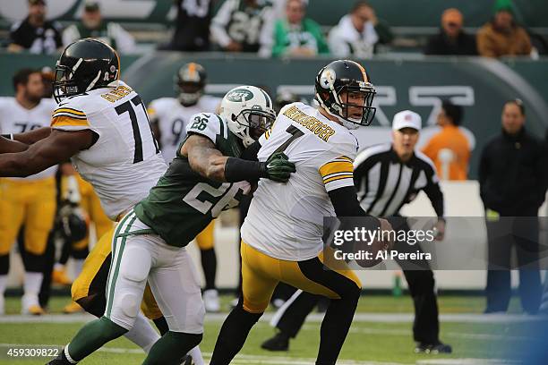 Quarterback Ben Roethlisberger of the Pittsburgh Steelers extends the play and gets the ball off under pressure from Dawan Landry of the New York...