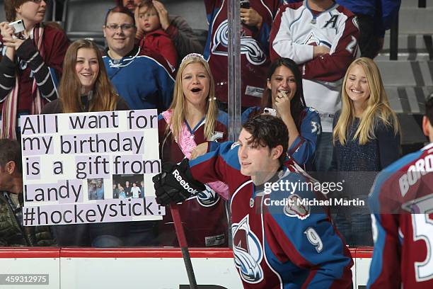 Fans try to attract the attentions of the Colorado Avalanche players as Matt Duchene skates by prior to the game against the Edmonton Oilers at the...