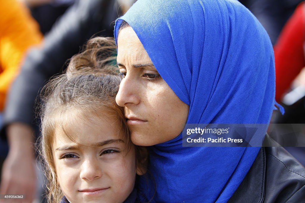 A Syrian mother holds her daughter in her arms. Syrian...