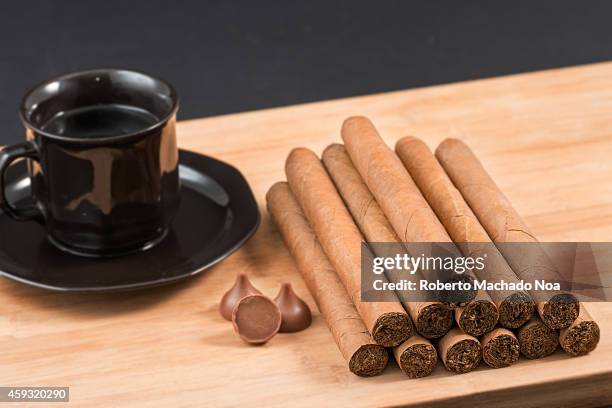 Worldwide famous Cuban cigars over wood with chocolates and coffee, hand rolled natural habanos an unhealthy tradition in the Caribbean Island.