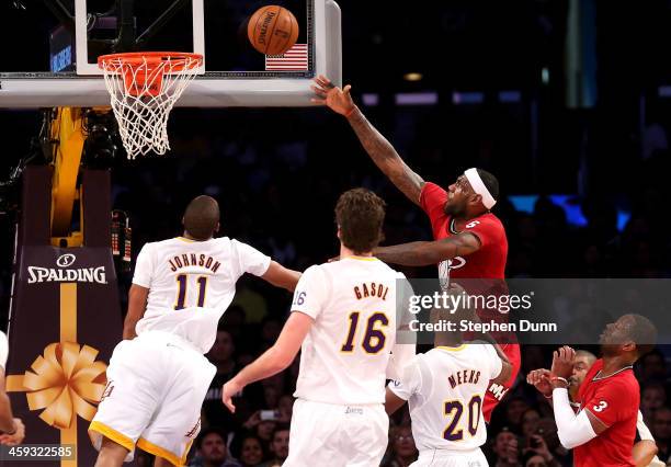 LeBron James of the Miami Heat shoots over Wesley Johnson and Jodie Meeks of the Los Angeles Lakers at Staples Center on December 25, 2013 in Los...