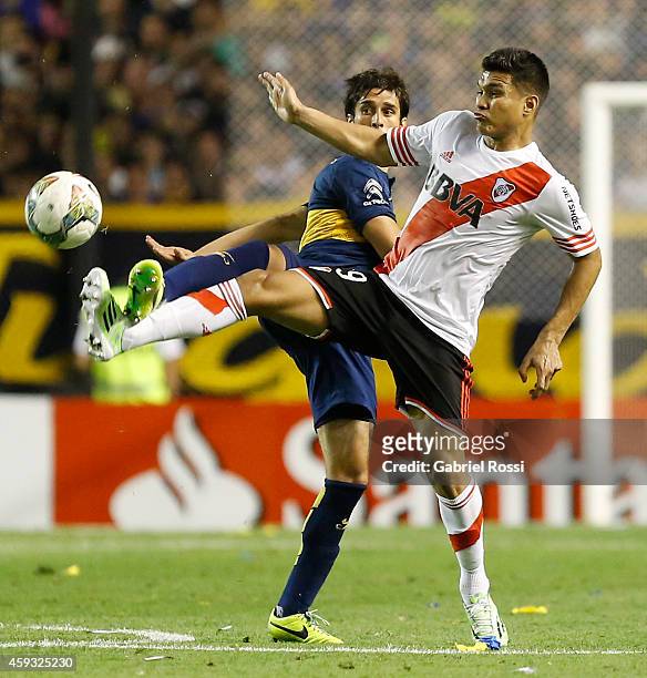 Teofilo Gutierrez of River Plate fights for the ball with Juan Forlin of Boca Juniors during a first leg semifinal match between Boca Juniors and...