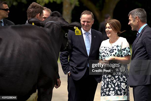 Prime Minister John Key, his wife Bronagh Key and MP Nathan Guy look at a cow before the arrival of Chinese President Xi Jinping to the NZ Bloodstock...