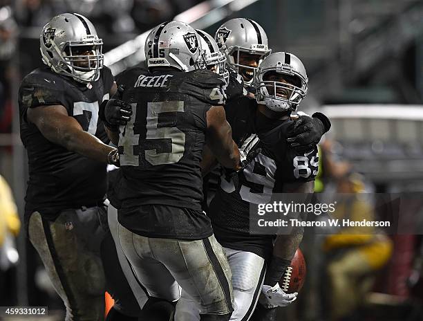 James Jones of the Oakland Raiders celebrates with teammates Marcel Reece and Menelik Watson after scoring a touchdown in the fourth quarter of the...