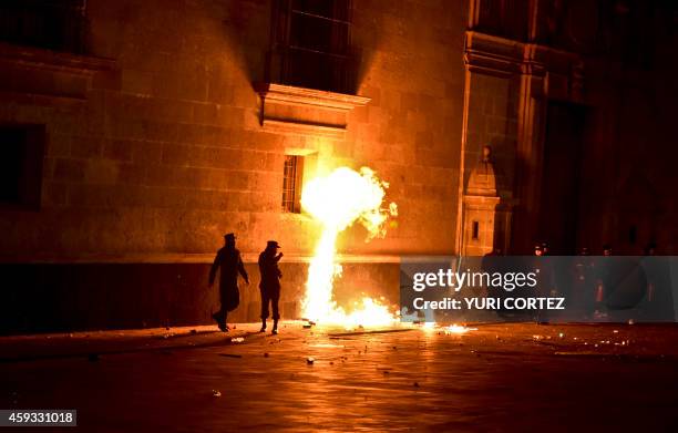 Students face riot police outside Mexico's National Palace during a protest over 43 missing students in Mexico City on November 20, 2014. Protesters...