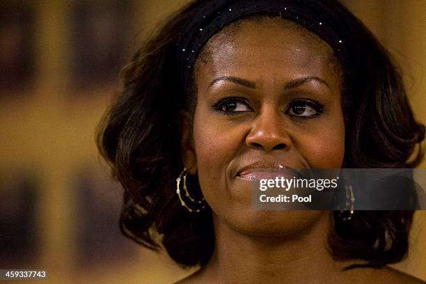 Ffirst lady Michelle Obama lisens as her husband U.S. President Barack Obama speaks during their annual trip to meet current and retired members of...