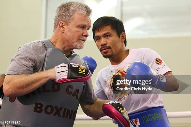 Manny Pacquiao works the mitts with trainer Freddie Roach during a workout session at The Venetianon November 21, 2014 in Macau, Macau.