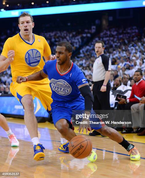 Chris Paul of the Los Angeles Clippers drives past David Lee of the Golden State Warriors during the first quarter at ORACLE Arena on December 25,...