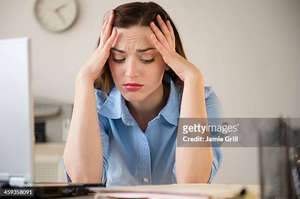 businesswoman frustrated at work - manos a la cabeza fotografías e imágenes de stock