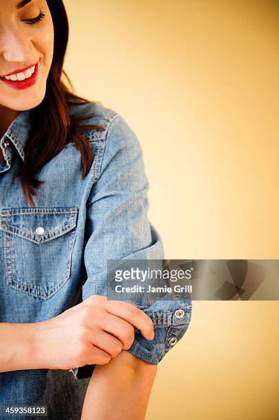 woman rolling up her sleeves - rolar imagens e fotografias de stock