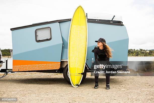 woman surfing in a wetsuit. - florence oregon stock pictures, royalty-free photos & images