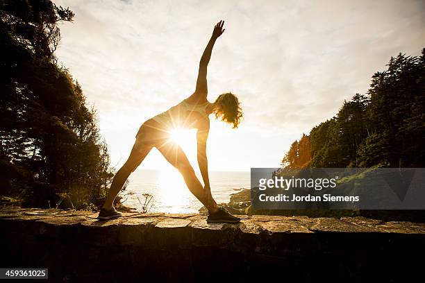 woman running for exercise. - woman stretching sunset stock-fotos und bilder