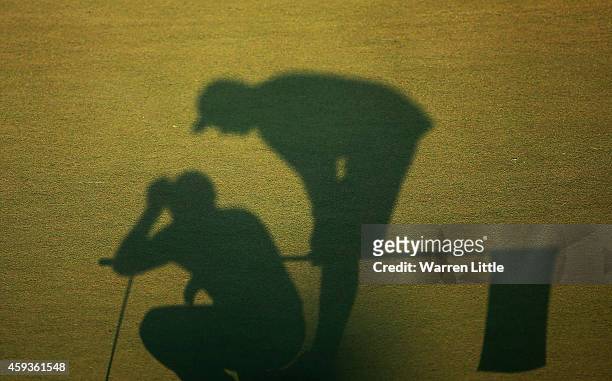 Silhouette of a caddie and player on the 18th green during the second round of the DP World Tour Championship at Jumeirah Golf Estates on November...