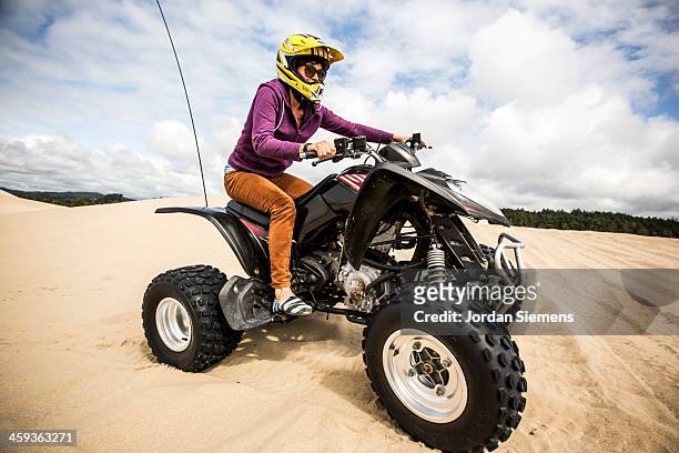 woman riding all-terrain vehicle. - quad foto e immagini stock