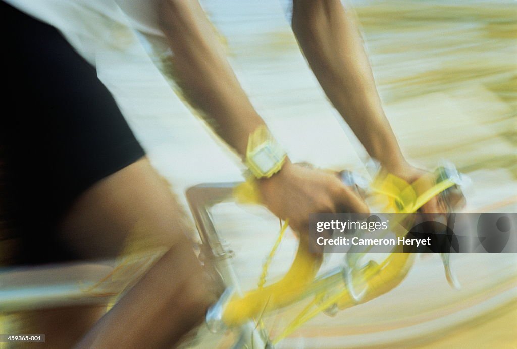 Cyclist with hands on handle bars, close-up,blurred action