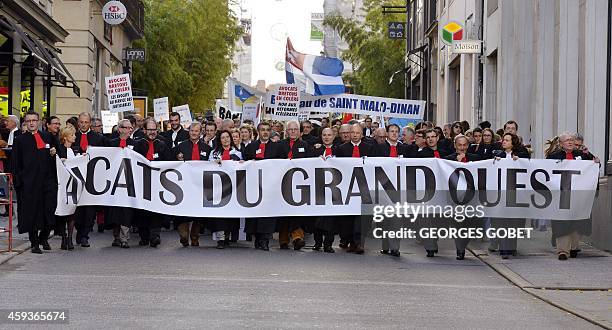 French lawyers dressed in their robes hold a banner during a demonstration against a reform of their professional status in Nantes, eastern France,...