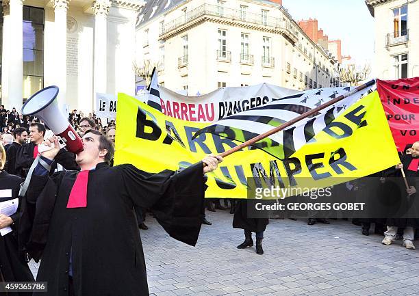 French lawyer wearing his robe speaks into a megaphone and waves a flag of Brittany as he takes part in a demonstration against a reform of the...