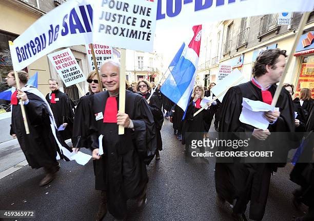 French lawyers dressed in their robes wave flags during a demonstration against a reform of their professional status in Nantes, eastern France, on...