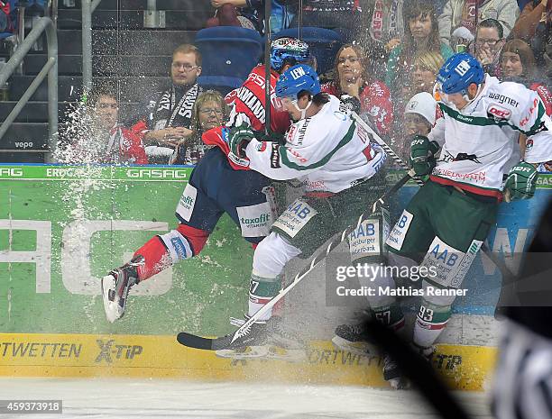 Jens Baxmann of the Eisbaeren Berlin throws a bodycheck into Daniel Weiss of the Augsburger Panther during the game between Eisbaeren Berlin and...