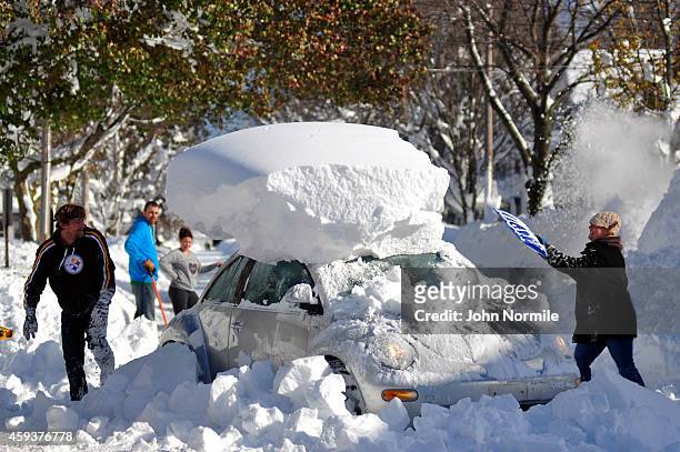 Michael Palmer and Carin Schultz work to clear her car of snow and remove it from Union street on November 20, 2014 in the suburb of Hamburg,...