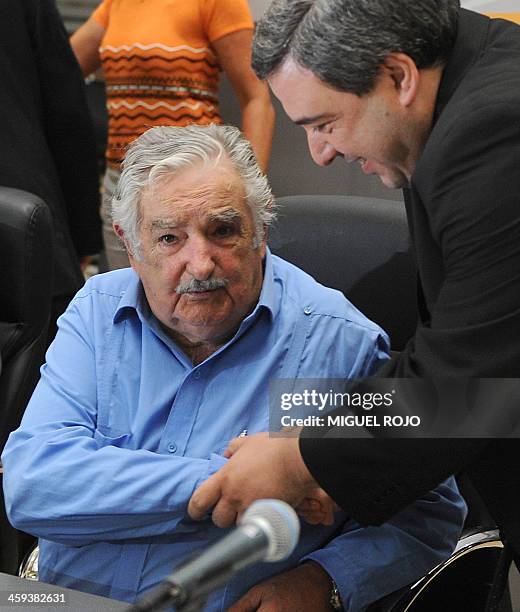 Uruguay's new Economy Minister Mario Bergara shakes hands with Uruguayan President Jose Mujica after assuming on December 26, 2013 in Montevideo....