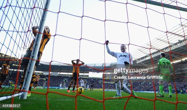 James Chester of Hull scores an own goal in front of Wayne Rooney of Manchester United during the Barclays Premier League match between Hull City and...