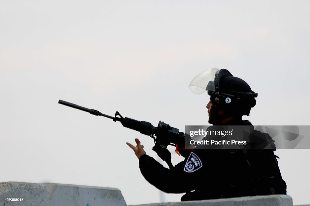 An Israeli soldier with his M-16 atop a cement barrier, at...