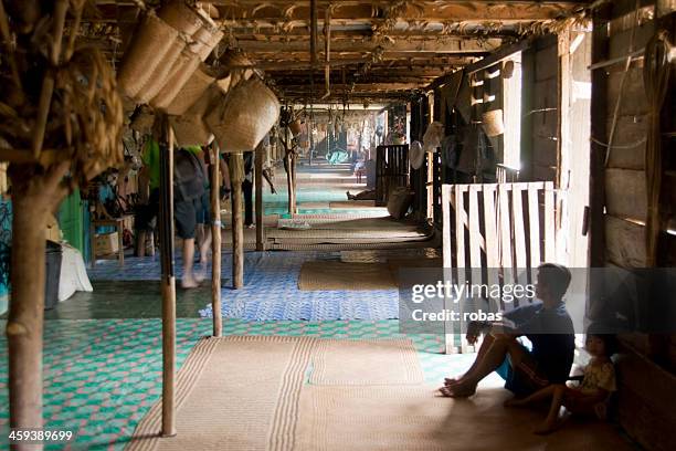 man of iban tribe sitting in longhouse. - iban stockfoto's en -beelden