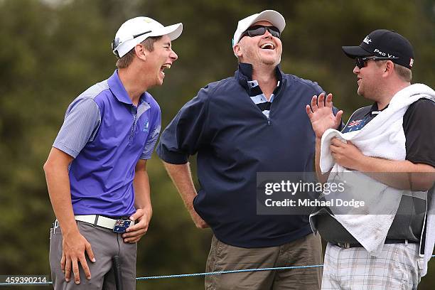 Australian amateur Lucas Herbert reacts with a friend and his caddie on the 17th green before his putt during day three of the Australian Masters at...